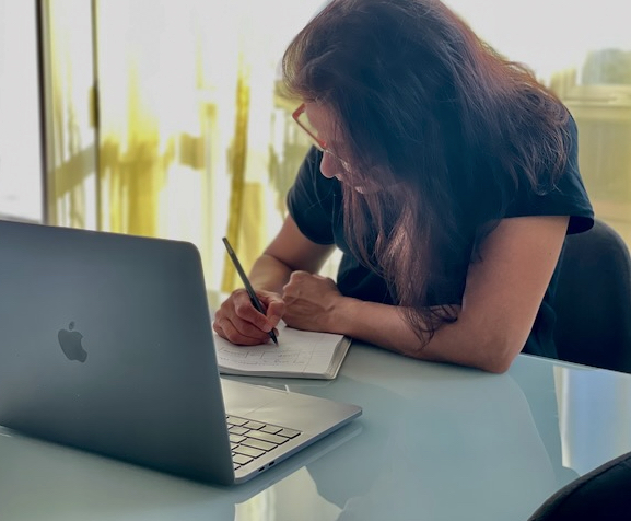 Woman sitting and writing on a note pad