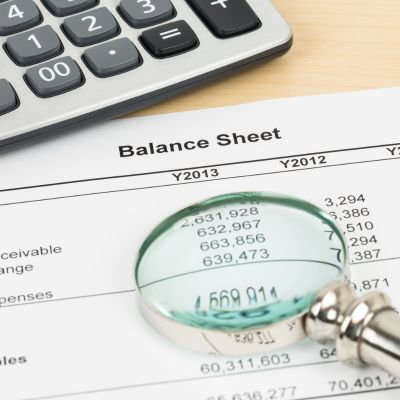 Image showing balance sheet with a magnifying glass and a calculator 