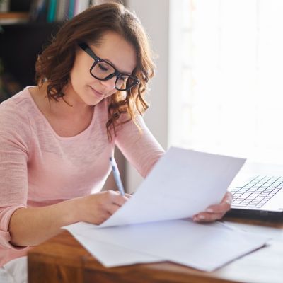 Woman holding a pen and paper for content writing for SEO optimization of her site