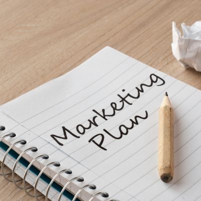 Image showing notebook with text Marketing Plan written on it, with a pencil on the side